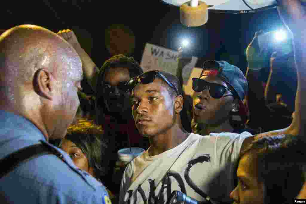 Missouri State Highway Patrol Captain Ron Johnson speaks to protesters as he walks through a peaceful demonstration as communities continue to react to the shooting of Michael Brown in Ferguson, Missouri, Aug. 14, 2014.