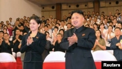 North Korean leader Kim Jong-Un (R) applauds with his wife Ri Sol-Ju (L) during a demonstration performance by the newly formed Moranbong band in Pyongyang in this undated picture released by the KCNA July 9, 2012