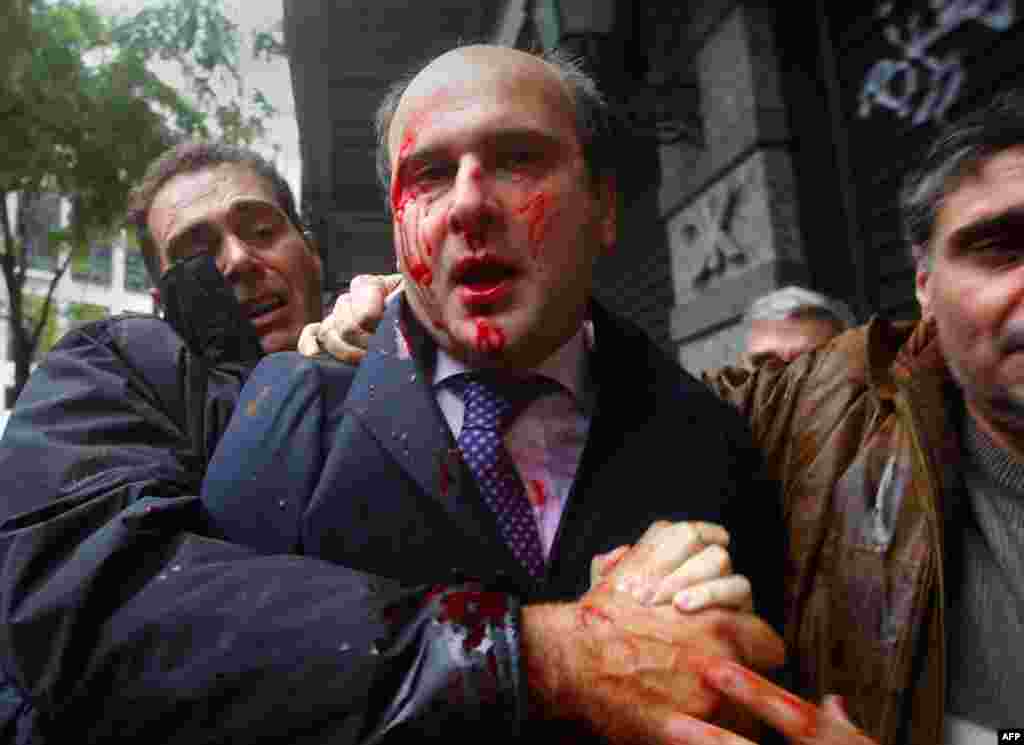 Former conservative minister of transportation Kostis Hatzidakis is covered with blood after about 200 leftists attacked him with stones and sticks, shouting: "Thieves! Shame on you!" in central Athens December 15.