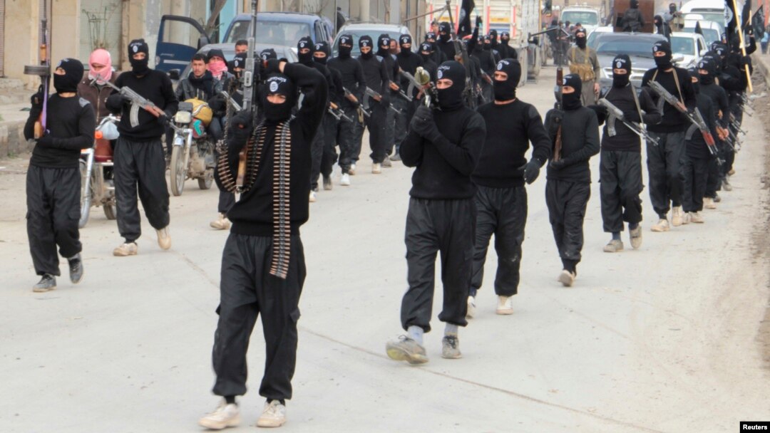 FILE - Fighters of al-Qaida linked Islamic State of Iraq and the Levant carry their weapons during a parade at the Syrian town of Tel Abyad, near the border with Turkey, January 2014.
