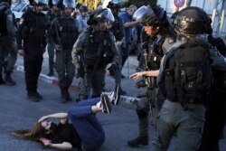 Israeli police scuffle with protesters in the Sheikh Jarrah neighborhood, east Jerusalem, May 15, 2021. Tensions began there earlier this month, when Palestinians protested attempts by settlers to forcibly evict Palestinian families from their homes.