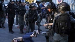 FILE - Israeli police scuffle with protesters in the Sheikh Jarrah neighborhood of east Jerusalem, May 15, 2021.