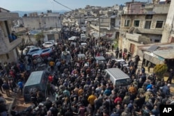 Relatives and neighbors attend the funeral procession for four Syrian security force members killed in clashes with loyalists of ousted President Bashar al-Assad in Al-Janoudiya, Syria, on March 8, 2025.