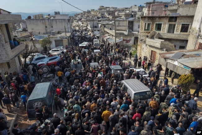 Relatives and neighbors attend the funeral procession for four Syrian security force members killed in clashes with loyalists of ousted President Bashar al-Assad in Al-Janoudiya, Syria, on March 8, 2025.