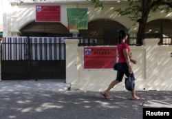 Seorang perempuan berjalan melewati masjid milik kelompok Ahmadiyah yang disegel oleh pihak berwenang di Jakarta Selatan, 9 Juli 2015. (Foto: Reuters)