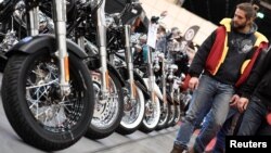 Harley-Davidson bikes are lined up at a bike fair.