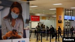 Penumpang mengenakan masker di Bandara Internasional Jorge Chavez yang masih terlihat sepi setelah ditutup selama enam bulan akibat pandemi COVID-19, di Lima, Peru, 5 Oktober 2020. (REUTERS/Sebastian Castaneda) 