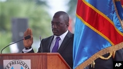 Incumbent Congo President Joseph Kabila holds the Congolese flag as he takes the oath of office as he is sworn in for another term, in Kinshasa, Congo, December 20, 2011.
