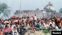ایوھیا میں قائم تاریخی بابری مسجد کو گرانے والے ہندو انتہاپسند نعرے لگا رہے ہیں۔ 6 دسمبر 1992