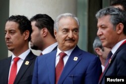 FILE - Khalifa Haftar, center, the military commander who dominates eastern Libya, leaves after an international conference on Libya at the Elysee Palace in Paris, May 29, 2018.