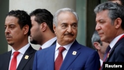 Khalifa Haftar, center, the military commander who dominates eastern Libya, leaves after an international conference on Libya at the Elysee Palace in Paris, May 29, 2018.