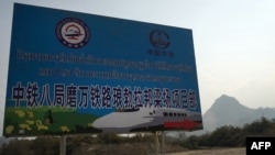 This picture taken on February 8, 2020 shows a sign in Lao and Chinese referring to the construction of the first rail line linking China to Laos, a key part of Beijing's 'Belt and Road' project across the Mekong, in Luang Prabang. (AFP)