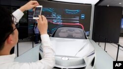 Visitors look at the Infiniti electric concept sedan at a showroom ahead of the Auto China 2018 to be held in Beijing, China, April 19, 2018.