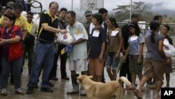 Presiden Filipina Benigno Aquino III (dua dari kiri, barisan depan) membagikan bantuan untuk para korban topan Bopha saat meninjau wilayah New Bataan, Compostela Valley di selatan Filipina (7/12). 