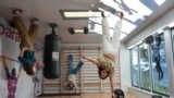 A group of friends pose for a picture that will be rotated upside down to create an optical illusion, at Paradox Museum Miami, Tuesday, Jan. 28, 2025, in Miami. (AP Photo/Rebecca Blackwell)