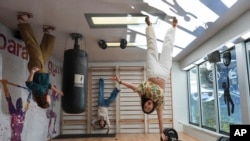 A group of friends pose for a picture that will be rotated upside down to create an optical illusion, at Paradox Museum Miami, Tuesday, Jan. 28, 2025, in Miami. (AP Photo/Rebecca Blackwell)