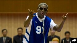 Dennis Rodman sings Happy Birthday to North Korean leader Kim Jong Un, seated above in the stands, before an exhibition basketball game at an indoor stadium in Pyongyang, North Korea, Jan. 8, 2014. 