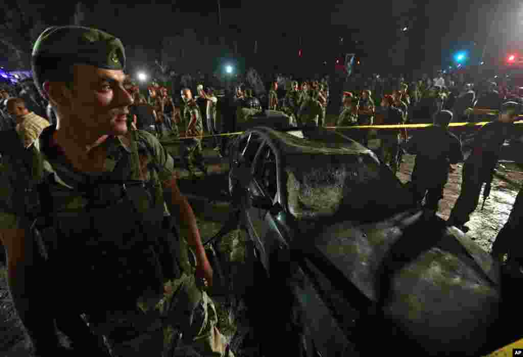 Lebanese soldiers and citizens gather at the site of a car bombing in a southern suburb of Beirut, June 24, 2014. 