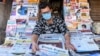 A vendor wearing a facemask amid concerns over the spread of the COVID-19 novel coronavirus, displays newspapers at his stall in Amritsar on March 20, 2020.