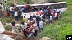 In this grab made from video provided by KK Productions, rescuers pull out passengers from a bus that fell into a gorge in Jagtiyal district of Telangana, India, Sept. 11, 2018. 