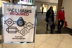 FILE - A "face masks required" sign is displayed at a shopping center in Schaumburg, Ill., Nov. 13, 2020.