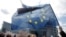 FILE - FILE - A demonstrator holds a European flag during a protest in front of the European Parliament in Strasbourg, France, March 26, 2019. 