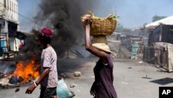 Pasan kap mache pezibleman pou al regle ativite yo nan moman kawochou tap boule nan Pòtoprens. 9 jiyè 2018.(Foto: AP/Dieu Nalio Chery)