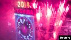 Fireworks explode past the Times Square Ball after it dropped to signal the start of the new year in Times Square, Midtown, New York January 1, 2014. REUTERS/Adrees Latif (UNITED STATES - Tags: SOCIETY) - RTX16YQG