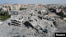 Bangunan tempat tinggal, yang hancur akibat serangan Israel selama konflik, menjadi reruntuhan, di tengah gencatan senjata sementara antara Israel dan Hamas, di selatan Kota Gaza 26 November 2023. (Foto: Reuters)