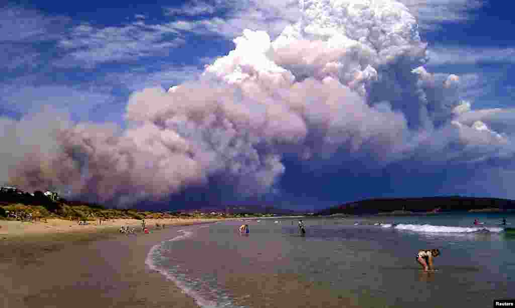 2013年1月4日山火的濃煙吹向澳大利亞霍巴特以東卡爾頓海灘的戲水者。