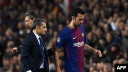 Sergio Busquets discute avec l'entraîneur Ernesto Valverde lors d'un match au Camp Nou de Barcelone, le 14 mars 2018.