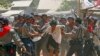 Polícia de Myanmar agride estudantes com bastões e deteve alguns ao dispersar um protesto de 200 pessoas que estavam há mais de uma semana em impasse com forças de segurança;<br />
Os estudantes protestavam uma nova lei que dizem vai acabar com a independência académica.