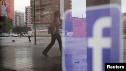 El logo de Facebook se puede observar en el reflejo de una ventana en una tienda en Málaga, España.