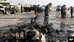 Iraqi security forces inspect the scene of a car bomb attack in Ramadi, 70 miles (115 kilometers) west of Baghdad, 12 Dec 2010