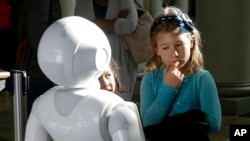 Emerson Hill, 6, interacts with Pepper the robot at Westfield Mall in San Francisco, Dec. 22, 2016.