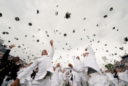 Graduates toss their hats after receiving their diplomas at the graduation and commissioning ceremony for the U.S. Naval Academy's Class of 2021, at the U.S. Naval Academy in Annapolis, Maryland.