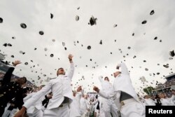 Graduates toss their hats after receiving their diplomas at the graduation and commissioning ceremony for the U.S. Naval Academy's Class of 2021, at the U.S. Naval Academy in Annapolis, Maryland.