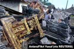 Seorang pria terlihat di antara bangunan pura yang rusak setelah gempa berkekuatan 4,8 melanda timur laut Bali, di Karangasem, Bali, 16 Oktober 2021. (Foto: Antara/Fikri Yusuf via REUTERS)