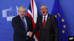 British Prime Minister Boris Johnson shakes hands with European Commission President Jean-Claude Juncker during a press point at EU headquarters in Brussels, Thursday, Oct. 17, 2019. 