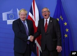 보리스 존슨 영국 총리(왼쪽)와 장클로드 융커 유럽연합 집행위원장이 17일 벨기에 브뤼셀 유럽연합 본부에서 새 브렉시트안에 합의한 후 악수하고 있다.