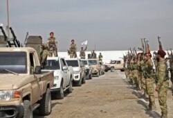 FILE - Turkish-backed Syrian rebels gather in al-Bab in the eastern countryside of Aleppo province as they prepare to take part in Turkey's invasion of northeastern Syria, Oct. 11, 2019.