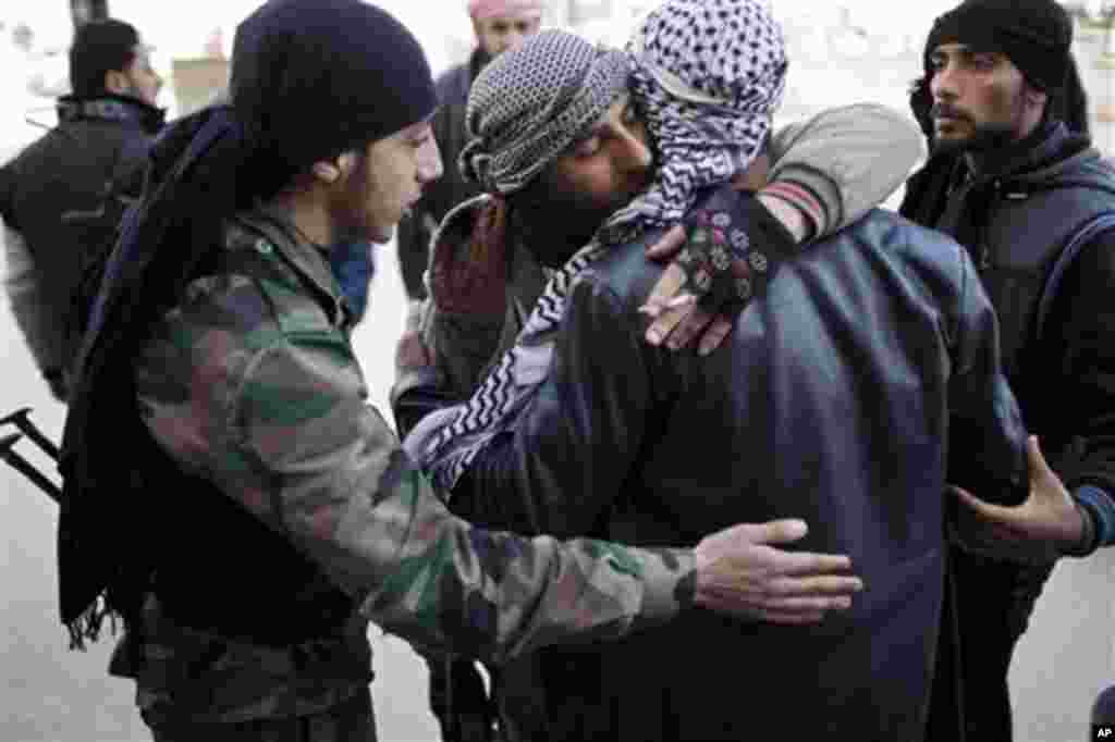 Free Syrian Army fighters console a comrade after an ambulance carried an injured friend to a hospital during fierce fighting against government troops in Idlib, north Syria, Saturday, March 10, 2012. U.N. envoy Kofi Annan met with Syrian President Bashar