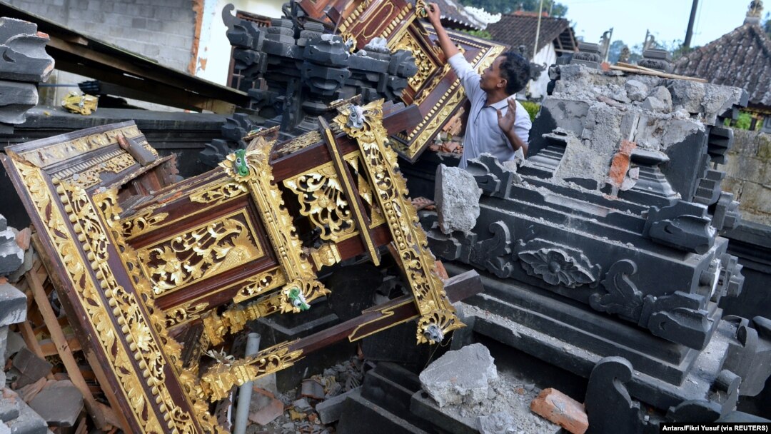 Seorang pria terlihat di antara bangunan pura yang rusak setelah gempa berkekuatan 4,8 melanda timur laut Bali, di Karangasem, Bali, 16 Oktober 2021, (Foto: Antara/Fikri Yusuf via REUTERS)