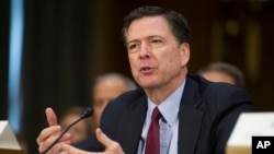 លោក James Comey ប្រធាន FBI ផ្តល់​សក្ខីកម្ម​នៅ​ចំពោះ​មុខ​គណៈកម្មាធិការ​ស៊ើបការ​របស់​ព្រឹទ្ធសភា​នៅ​ក្នុង​សវនាការ​ស្តី​ពី​សកម្មភាព​ស៊ើបការ​សម្ងាត់​របស់​រុស្ស៊ី នៅ​ឯ​វិមាន Capitol Hill ក្នុង​រដ្ឋធានី Washington កាល​ពី​ថ្ងៃ​ទី​១០ ខែ​មករា ឆ្នាំ​២០១៧។ (រូបថត៖ AP/Cliff Owen)