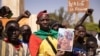 Des manifestants rassemblés à Ouagadougou pour montrer leur soutien aux militaires tiennent une photo du lieutenant-colonel Paul-Henri Sandaogo Damiba, chef de la mutinerie et du Mouvement patriotique pour la protection et la restauration (MPSR) le 25 janvier 2022.