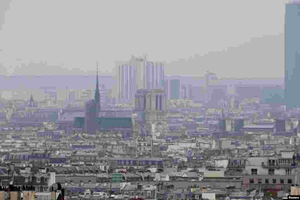 Kabut asap atau smog yang menyelimuti Gereja Notre Dame dan kota Paris (17/3) mendorong pemerintah memberlakukan aturan yang membatasi jumlah kendaraan di jalan ibukota dan pinggiran kota. (Reuters/Charles Platiau)