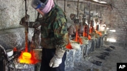 Ren Limin, a worker at the Jinyuan Company's smelting workshop, prepares to pour the rare earth metal Lanthanum into a mold near the town of Damao in China's Inner Mongolia Autonomous Region Oct. 31, 2010.