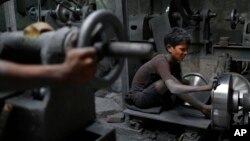 FILE - A boy, 11, works at a factory that makes metal utensils in Dhaka, Bangladesh, June 12, 2016. 
