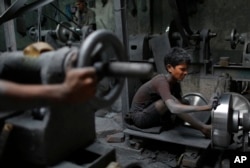 ڈھاکہ کی ایک فیکٹری میں مزور بچے کام کر رہے ہیں۔ فائل فوٹو