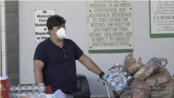 Un hombre, con mascarilla y con el carrito lleno, tras salir de hacer la compra en un supermercado de Miami Beach (Florida).
